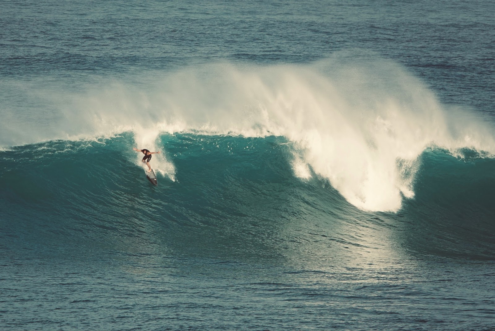 A professional surfer catching a wave at Banzai Pipeline on O‘ahu’s North Shore.