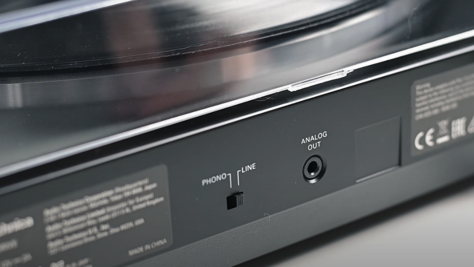 Close-up of a turntable's back panel showing a switch between PHONO and LINE. 