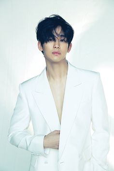 This contain Kim Soo Hyun in a white suit with his hands on his hips and looking at the camera