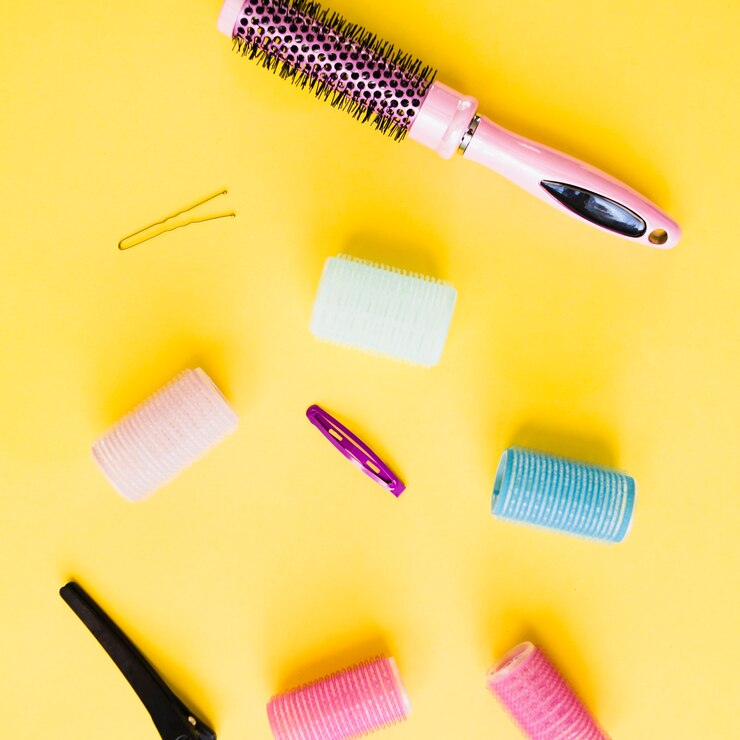 Comb and rollers on yellow background