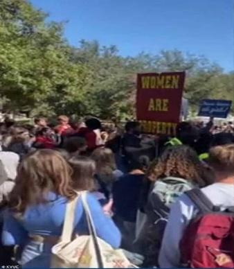 A group of people holding signs

Description automatically generated