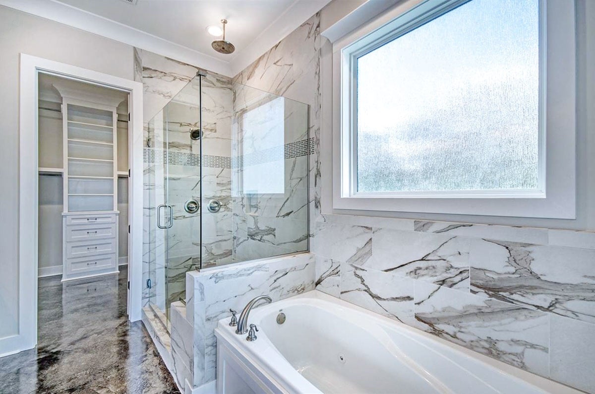 There's also a walk-in shower and a deep soaking tub fixed under the picture window.