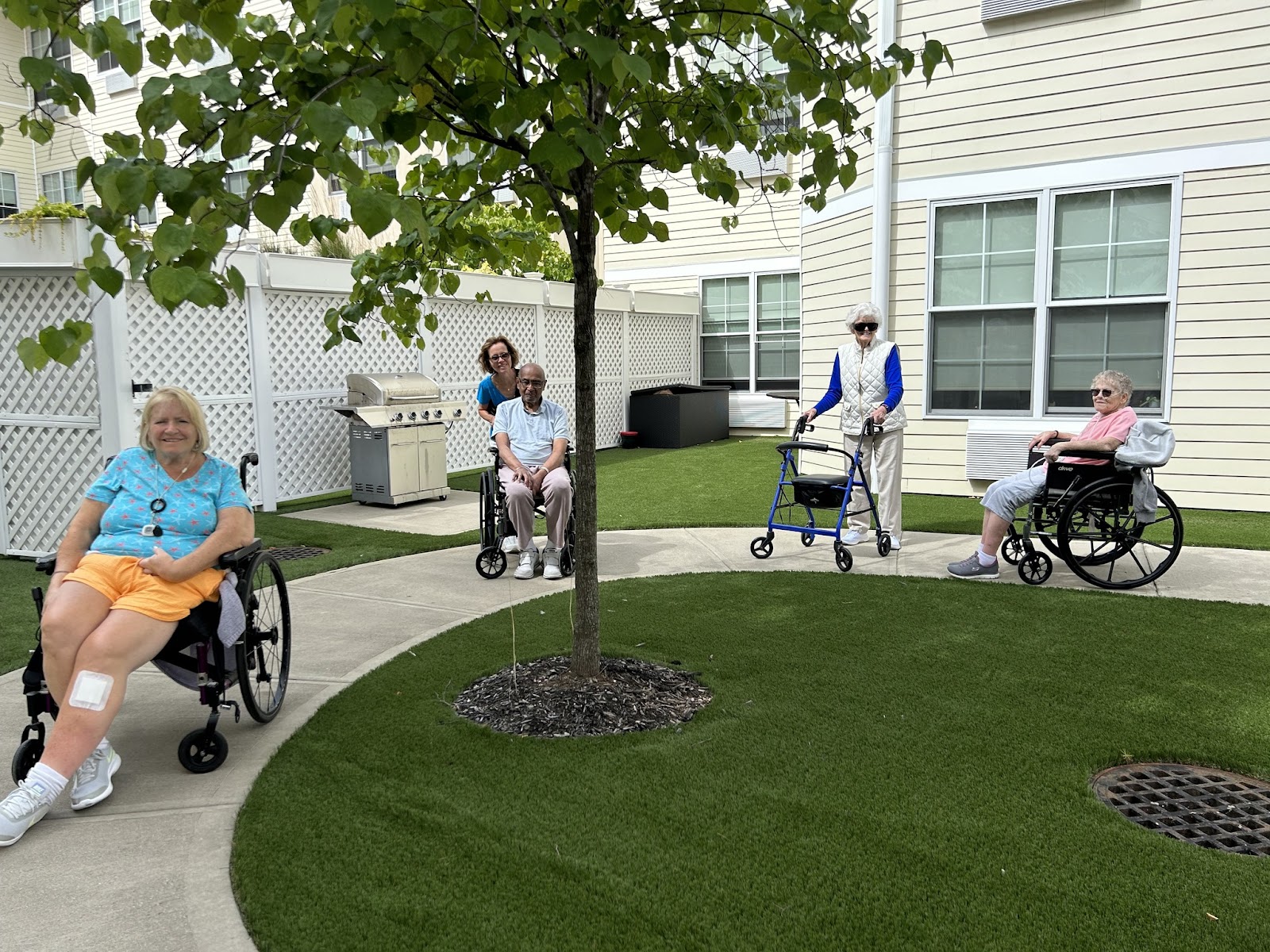 Village Green dementia patients in wheelchairs outside on the Village Green courtyard terrace