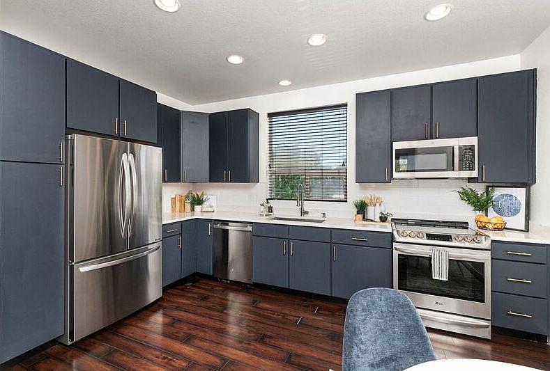 A kitchen with dark cabinets and a wood floor

AI-generated content may be incorrect.