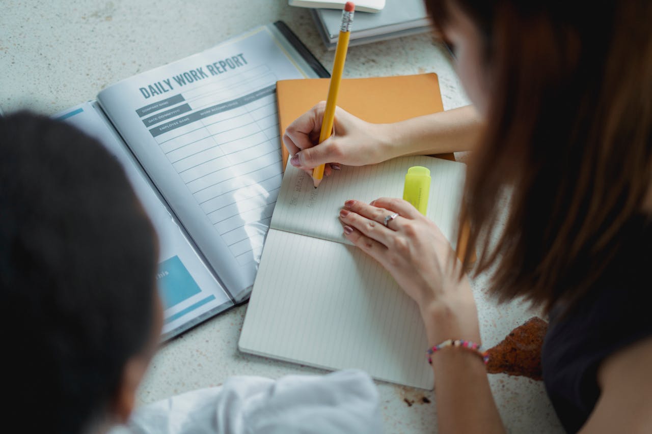 A women writing on a notebook about Daily Reviews