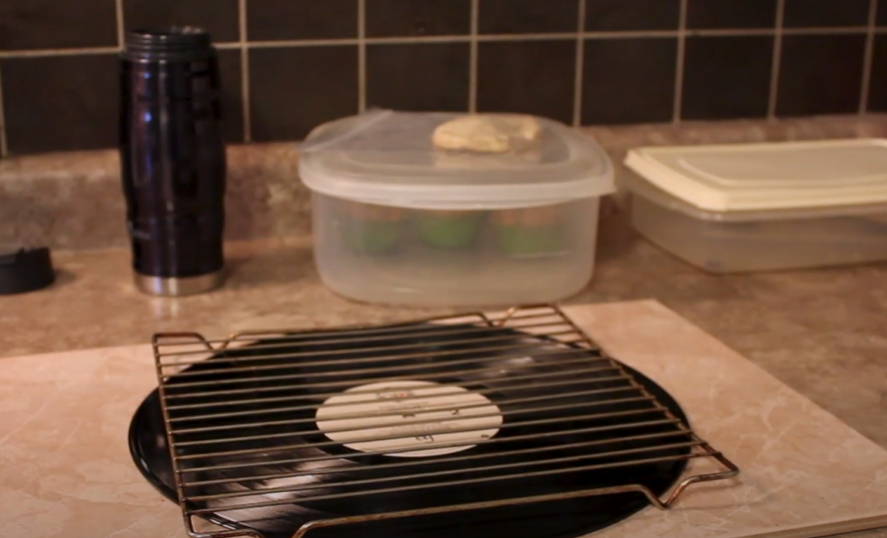 Vinyl record placed under a cooling rack on a kitchen countertop.