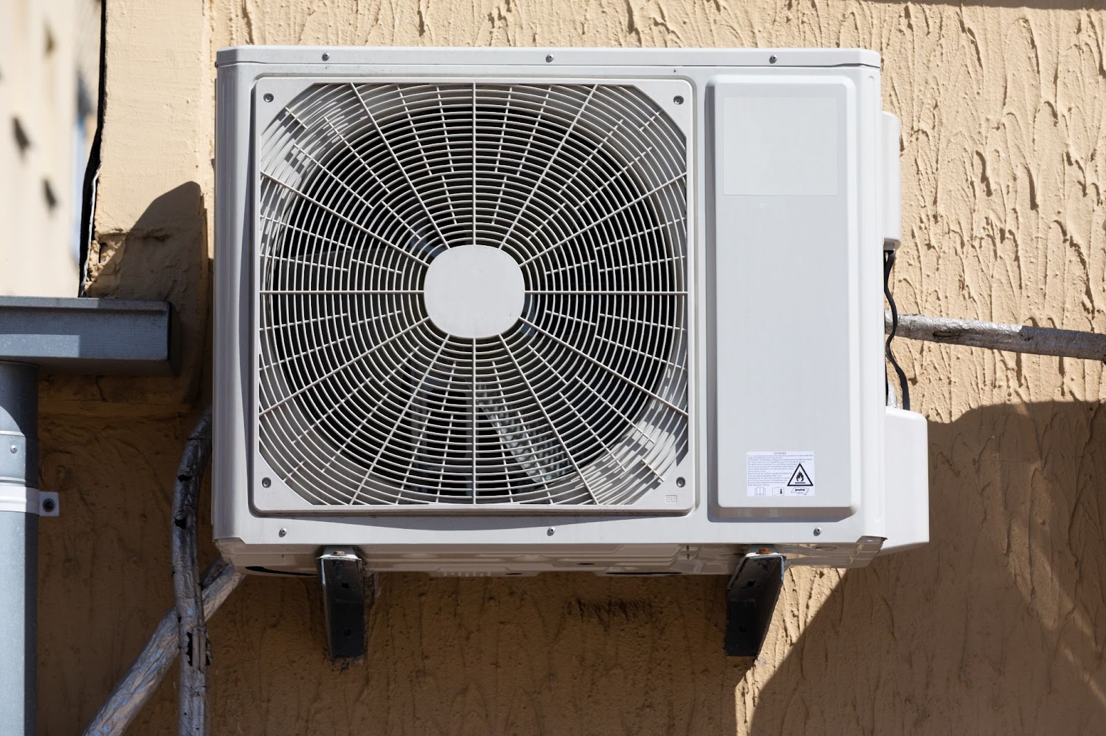 Residential AC unit attached to an exterior wall. 