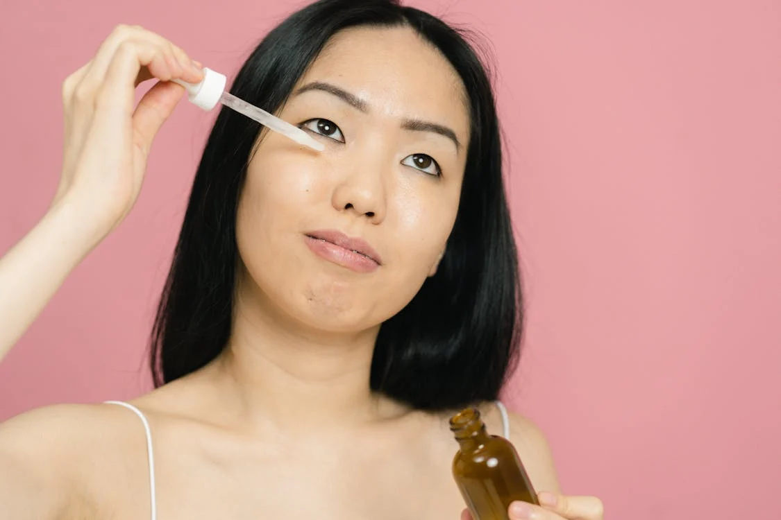 girl applying peptide serum on face