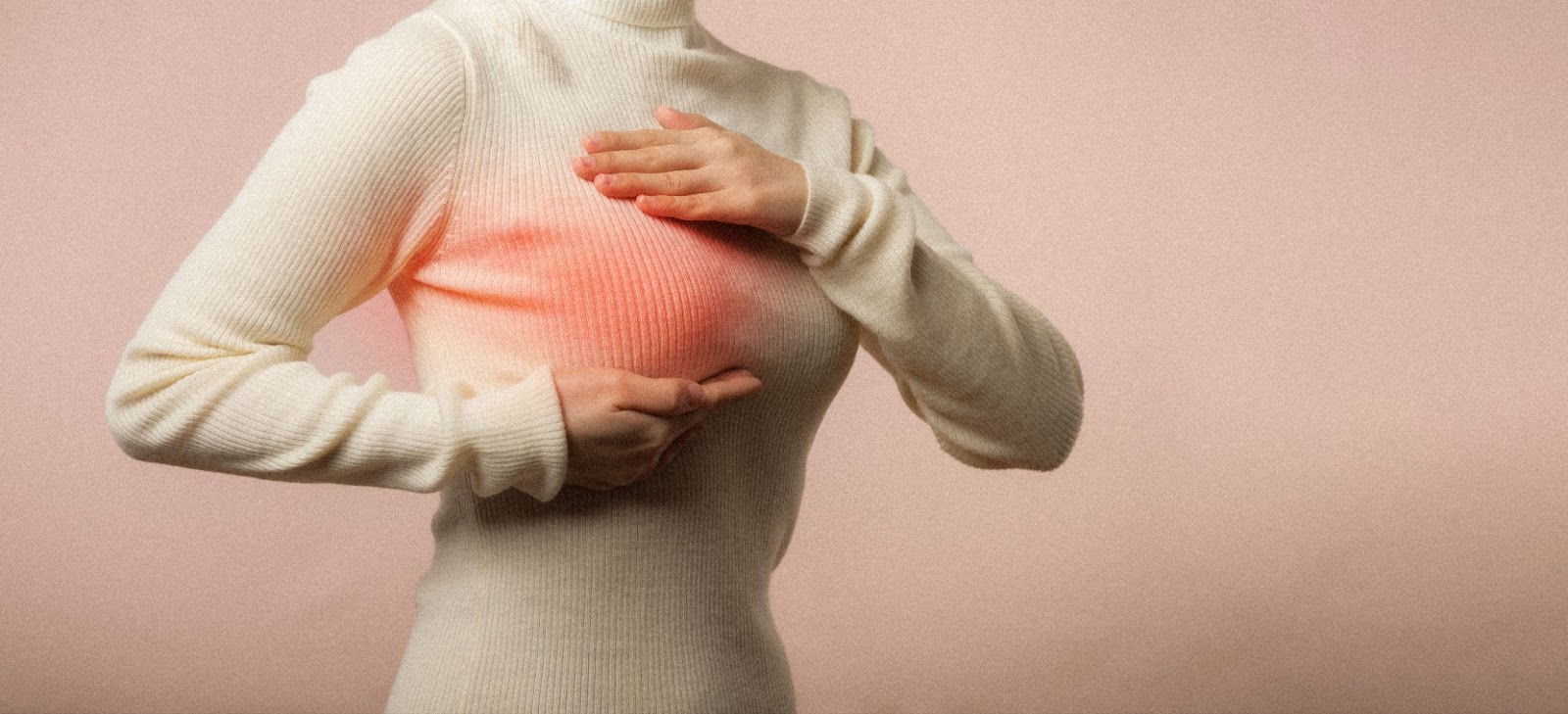 Woman checking lumps on her breast for signs of breast cancer on pink background