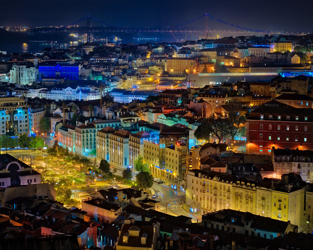 Night view of Lisbon with brightly lit buildings.