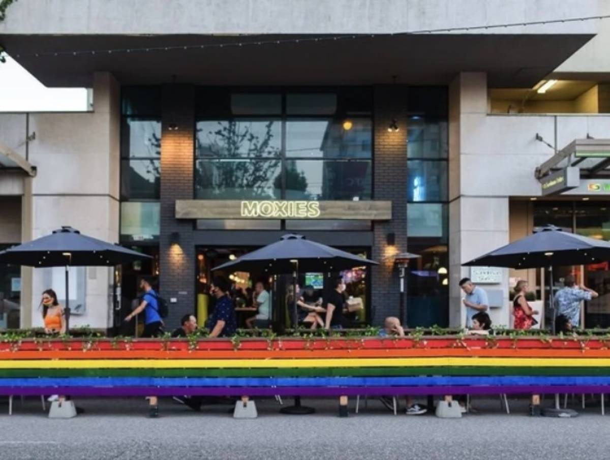 The outside of Moxies on Davie, with a rainbow barrier around its patio