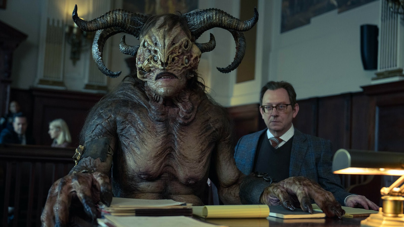 El actor Michael Emerson al lado de un sorprendente monstruo de cuernos en la serie Evil, que regresa con su temporada 4 en Paramount+. 