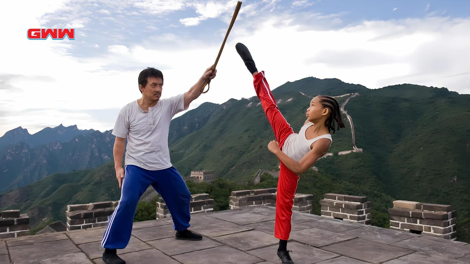  Jackie Chan training Jaden Smith with a staff on a mountain.