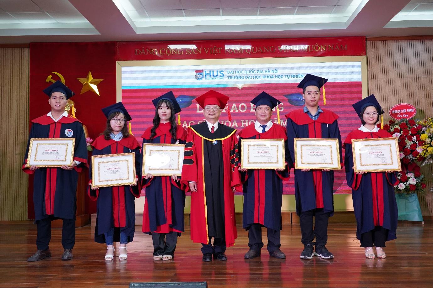 A group of people in graduation gowns holding certificates

AI-generated content may be incorrect.