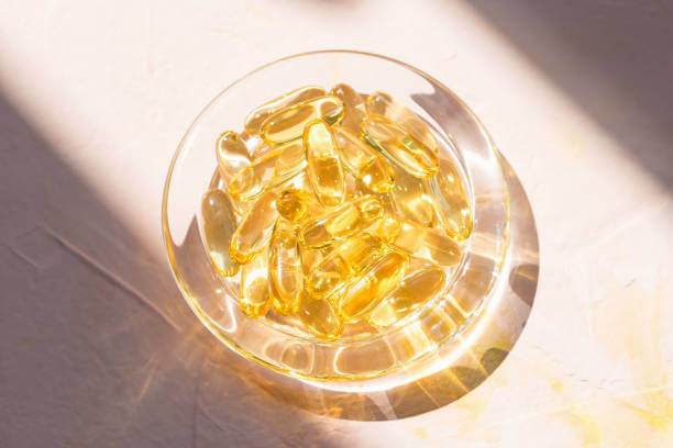 A close-up shot of golden fish oil capsules on a white surface, emphasizing their purity and rich omega-3 content.