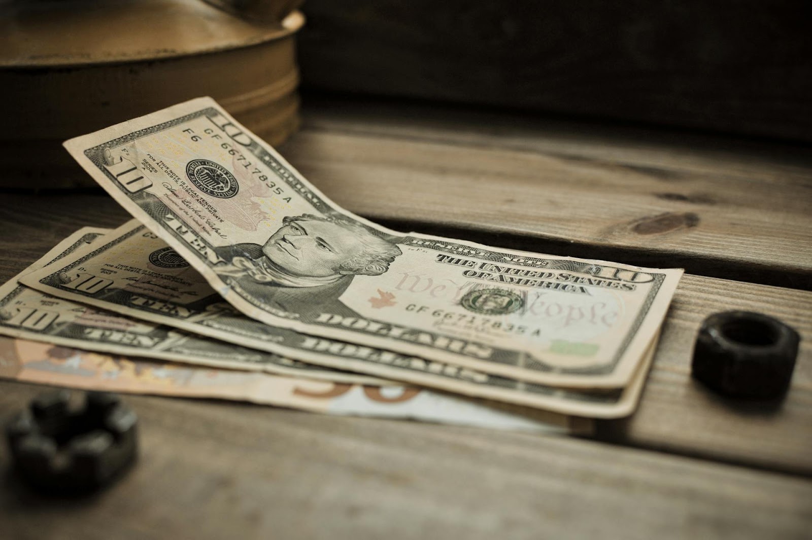 10 U.S. Dollar bills lying on a wooden surface | Source: Pexels