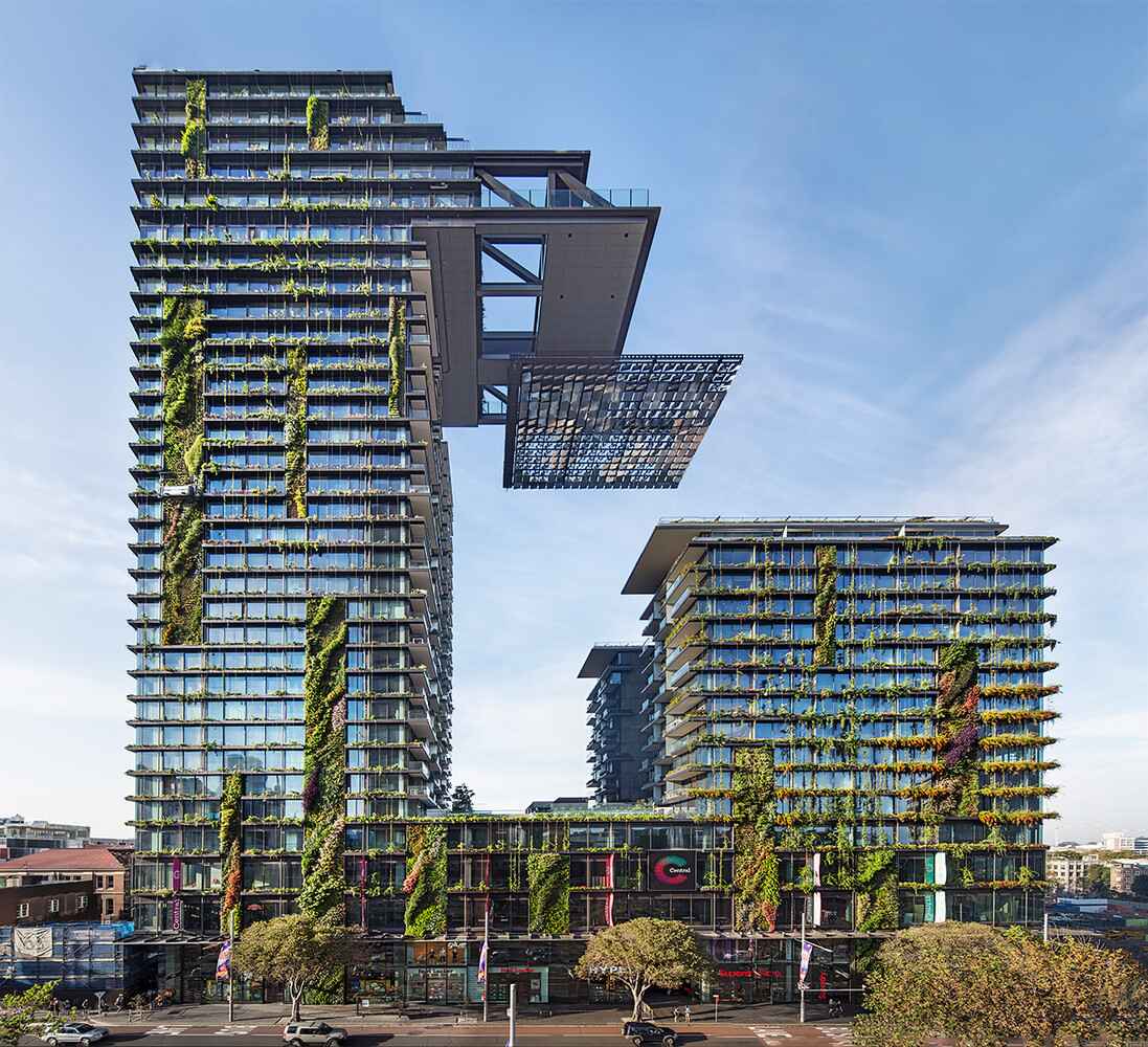 A modern high-rise building, a beacon of sustainability, showcases vertical gardens and greenery woven into its facade designs.