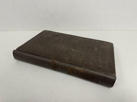 A book with a leather cover

Description automatically generated