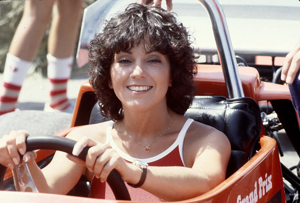 Joyce DeWitt, icône de la sitcom Vivre à trois (Three's Company) au volant d'une voiture.