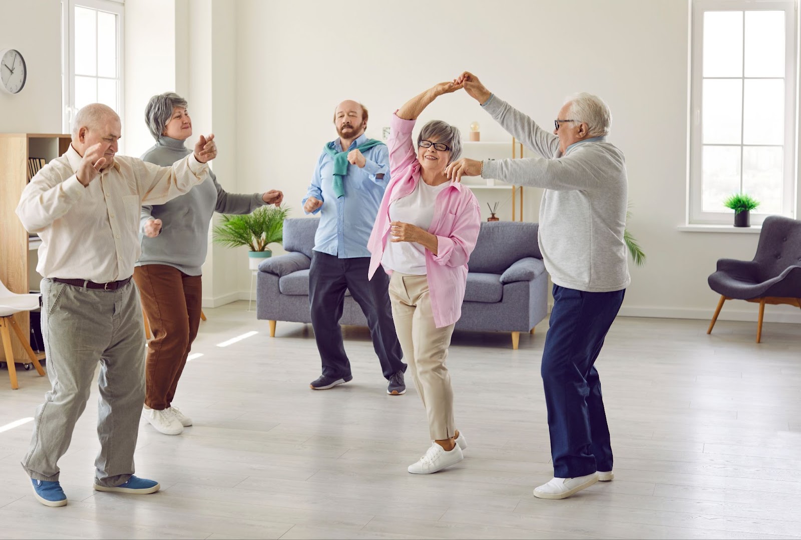 A group of seniors having fun while dancing together.