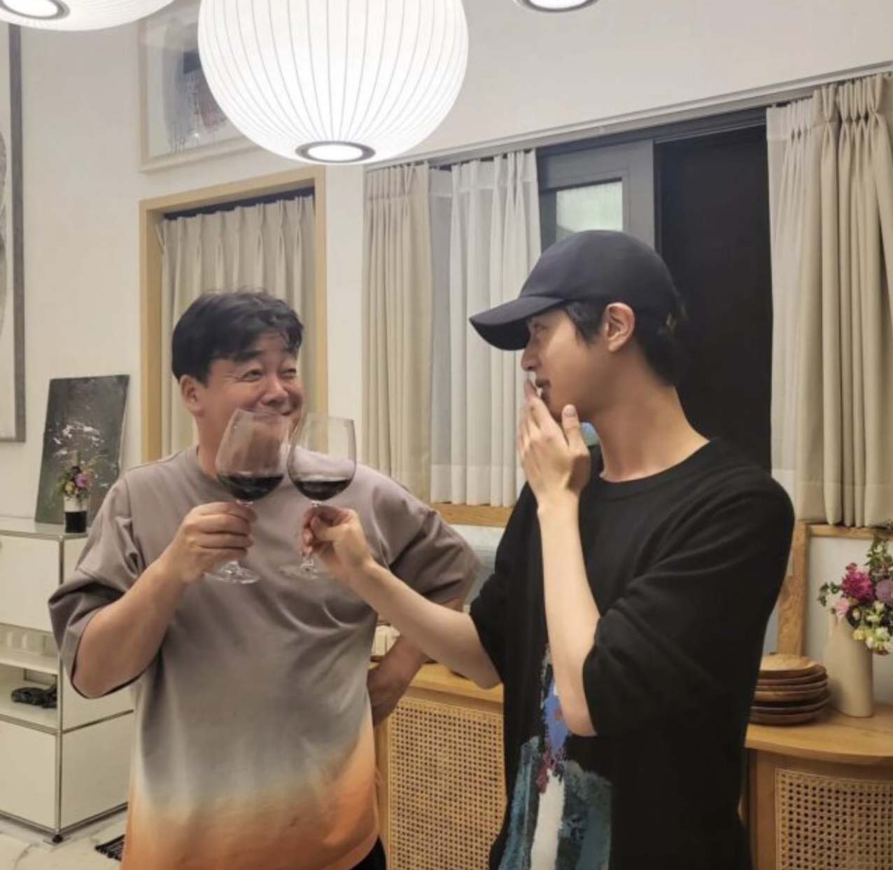 A picture of BST Jin and chef Baek Jong Won having a drink together 