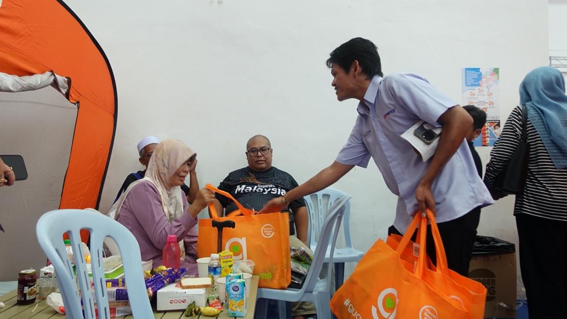 A person holding orange bags

Description automatically generated