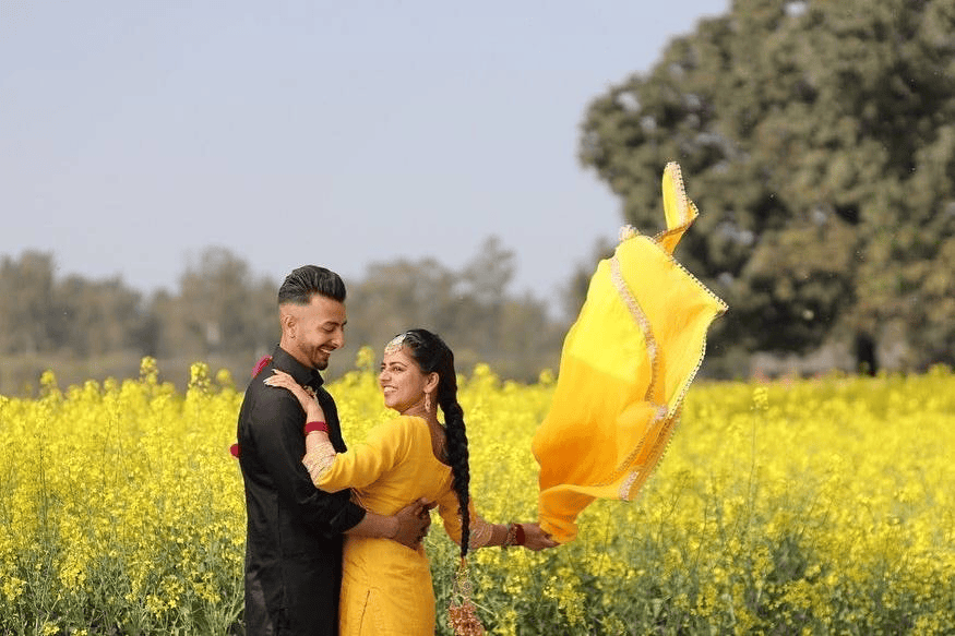 Pre-wedding shoot in Rupnagar by the serene lakeside, capturing the couple’s love against a bright sky