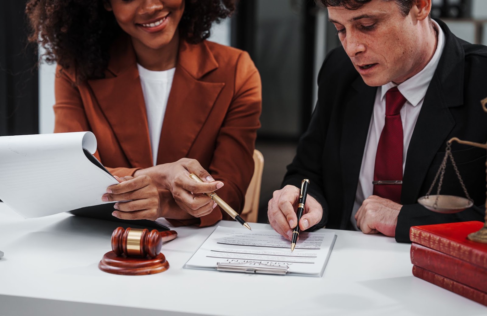 A female lawyer advises his male client on legal ownership during a business and financial consulting session.