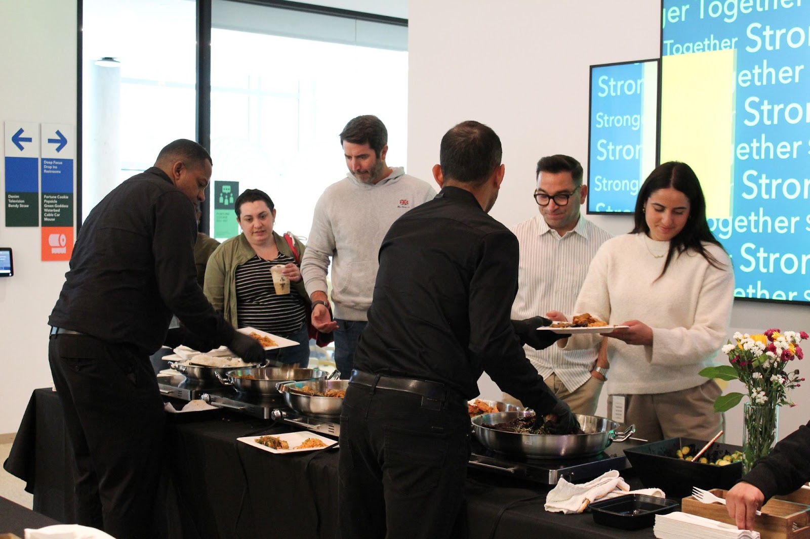 Office employees eating Superfine Kitchen's family-style catering 