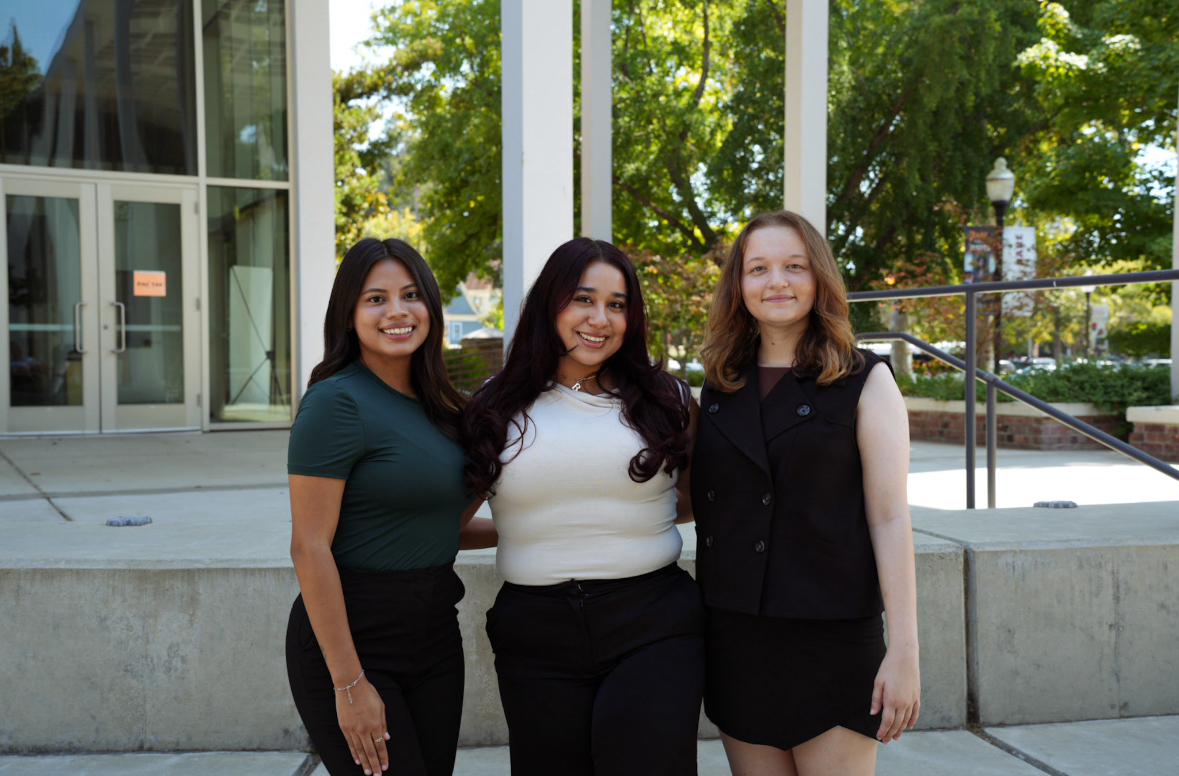  Esmeralda Barajas (left to right), Bella Anguiano and Talia Kennedy stand outside of the performance art building and pose for a photograph.
