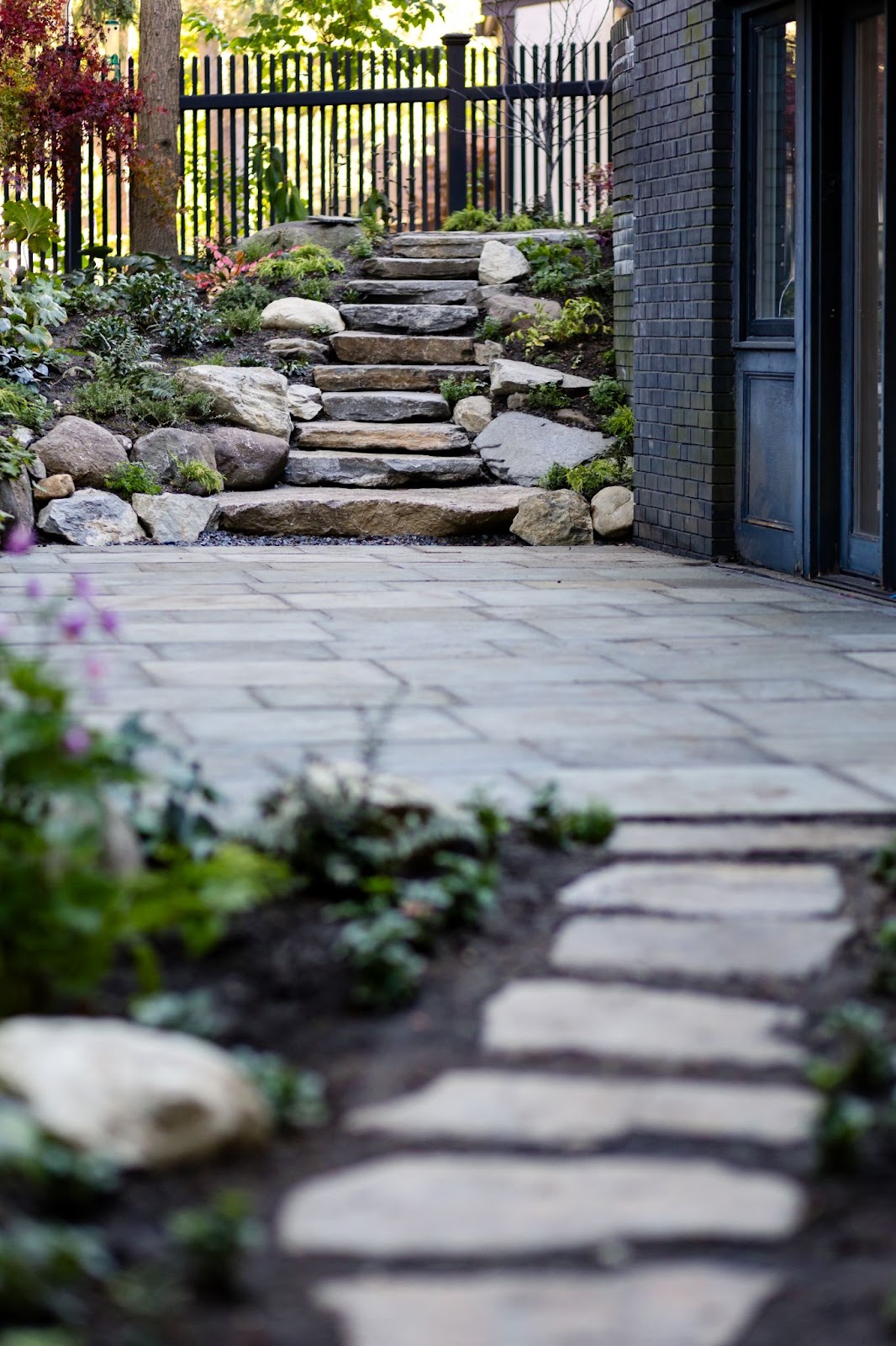 A hardscape walkway includes stone steps