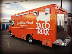 This contains  an image of orange taco truck parked in a parking lot