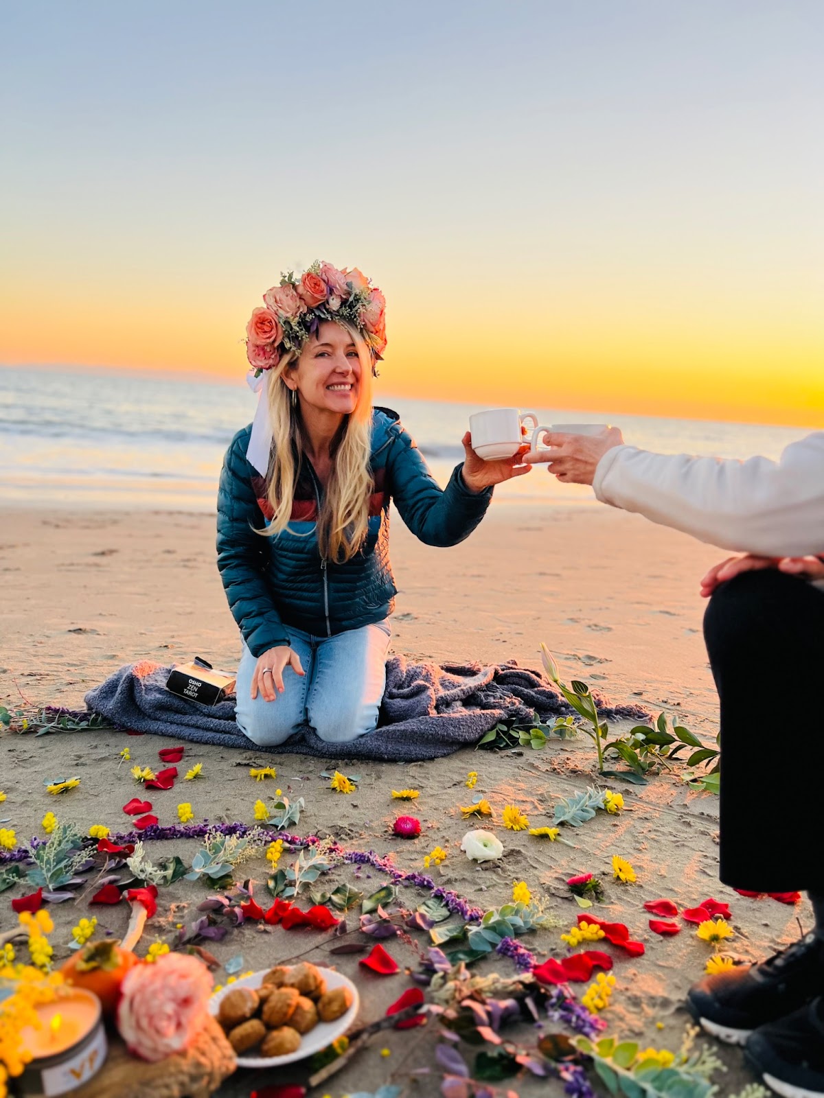 woman in blue jacket with flowers bouquet in hair on the beach with sunset with flowers