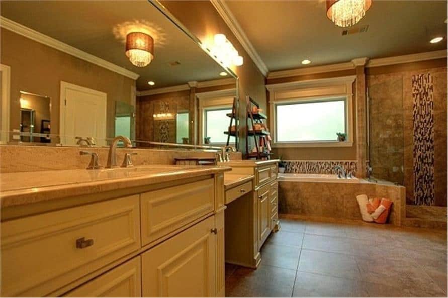 At the end of the vanity is the drop-in bathtub brightened by a picture window.