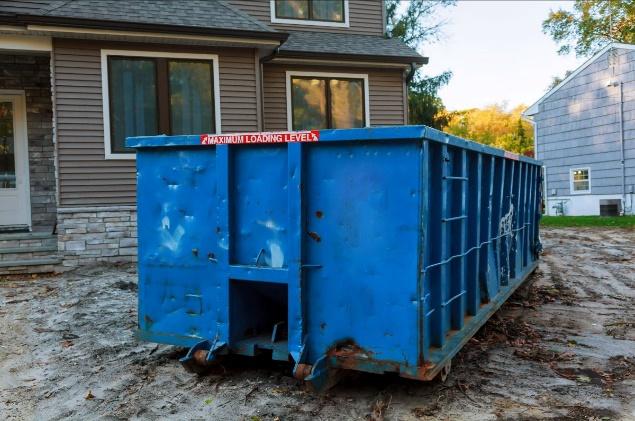 A blue dumpster in front of a house

Description automatically generated