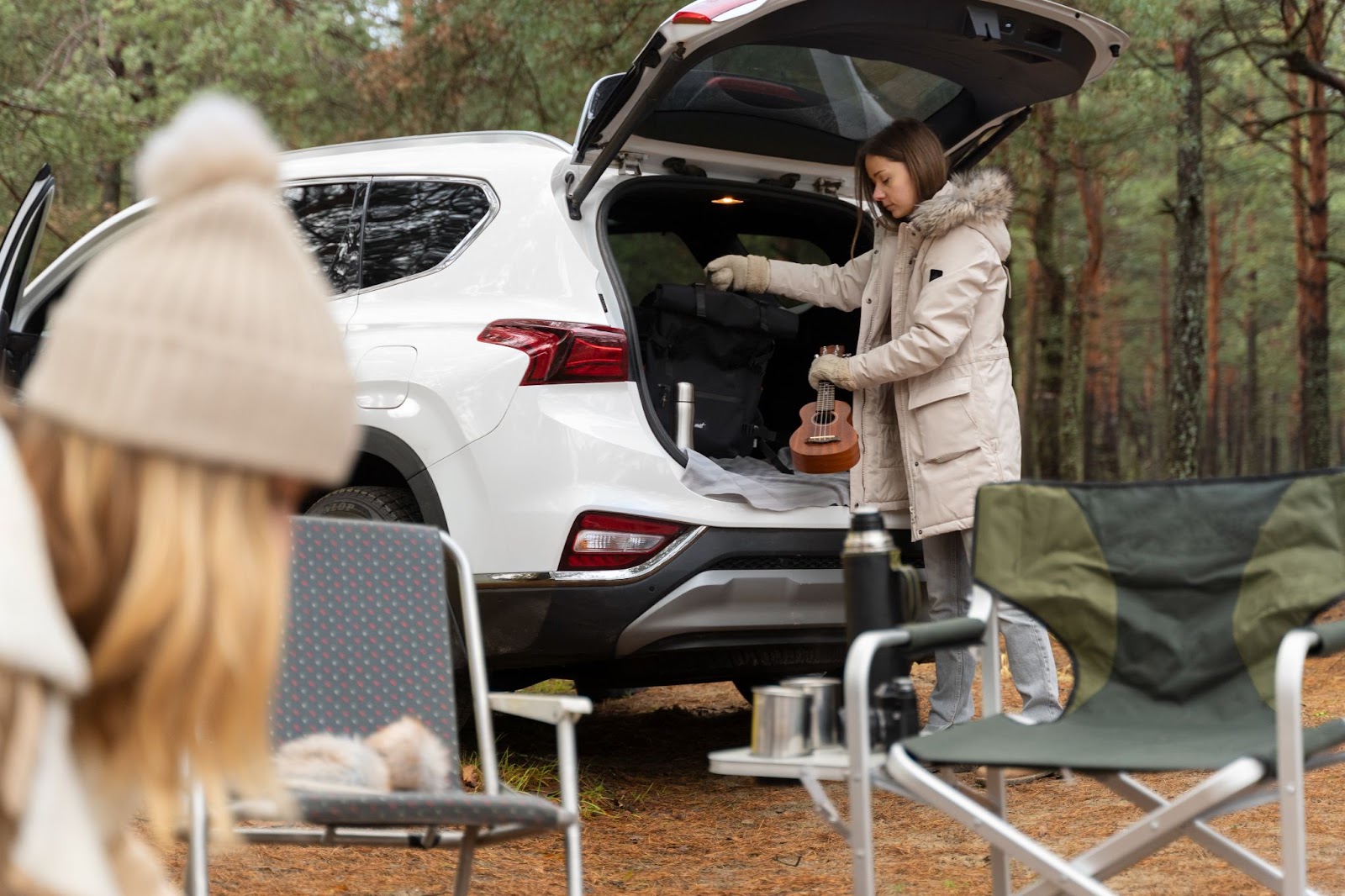 Woman reaching into the back of a camping SUV, using interior storage suited for long trips.