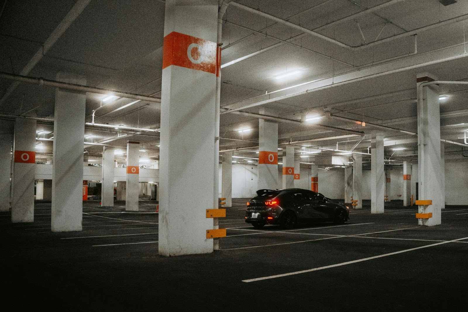 A car parked in a parking lot at night