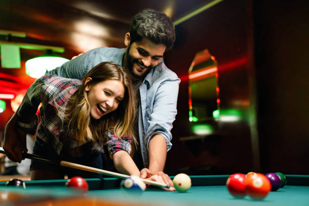 Pre-wedding shoot with a couple smiling while playing snooker, adding excitement to their photos