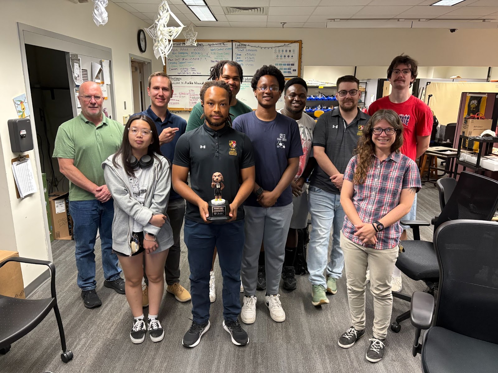 Khalil is holding the Gritty Award Trophy with the Av members standing by him.