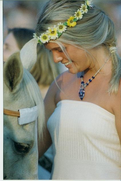 A person with flowers in her hair and a white horse

AI-generated content may be incorrect.