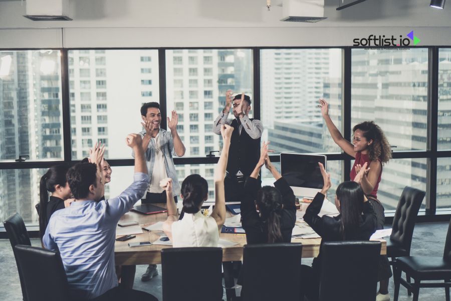 Group of people celebrating in an office meeting room.