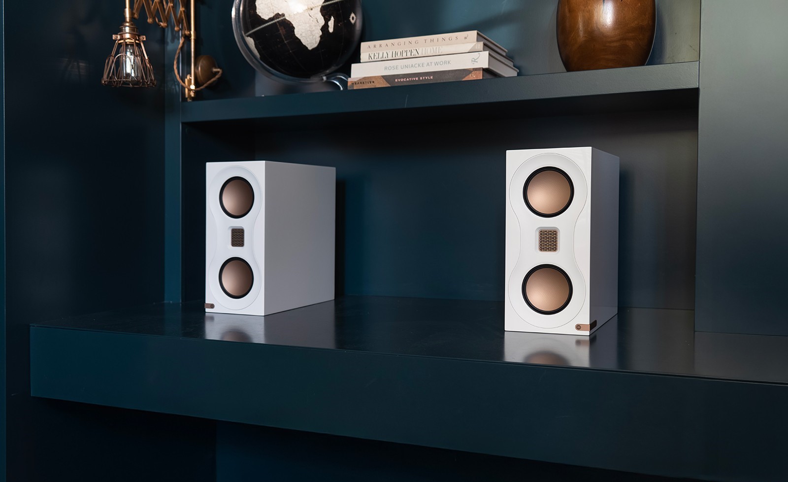 Monitor Audio Studio 89 bookshelf speakers on shelf.