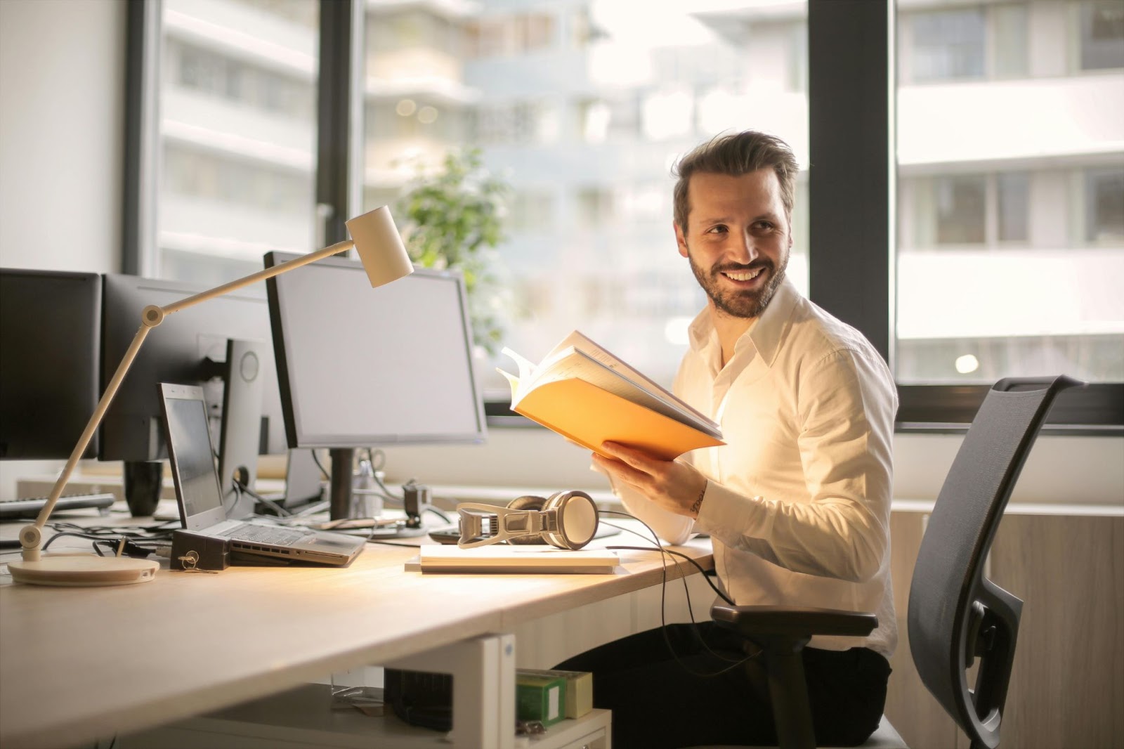 Man Reading Book Within an Office Setting