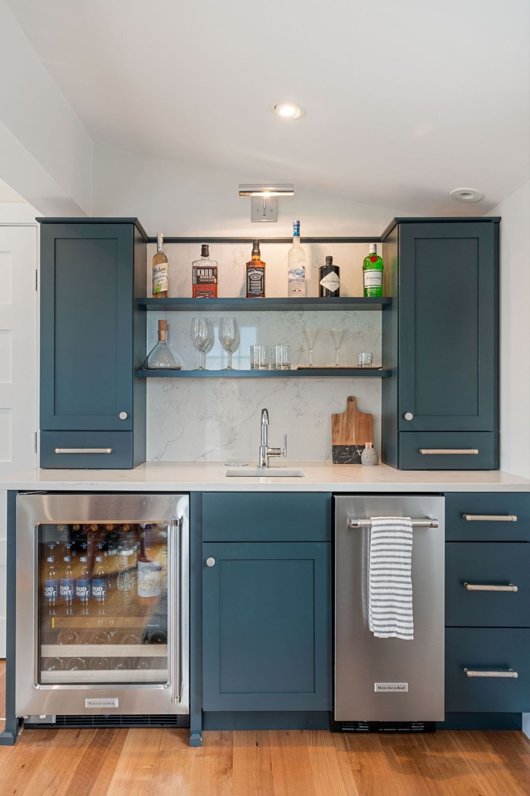 This image depicts a stylish kitchen bar area with open shelving cabinets, enhancing the airy feel of the space.