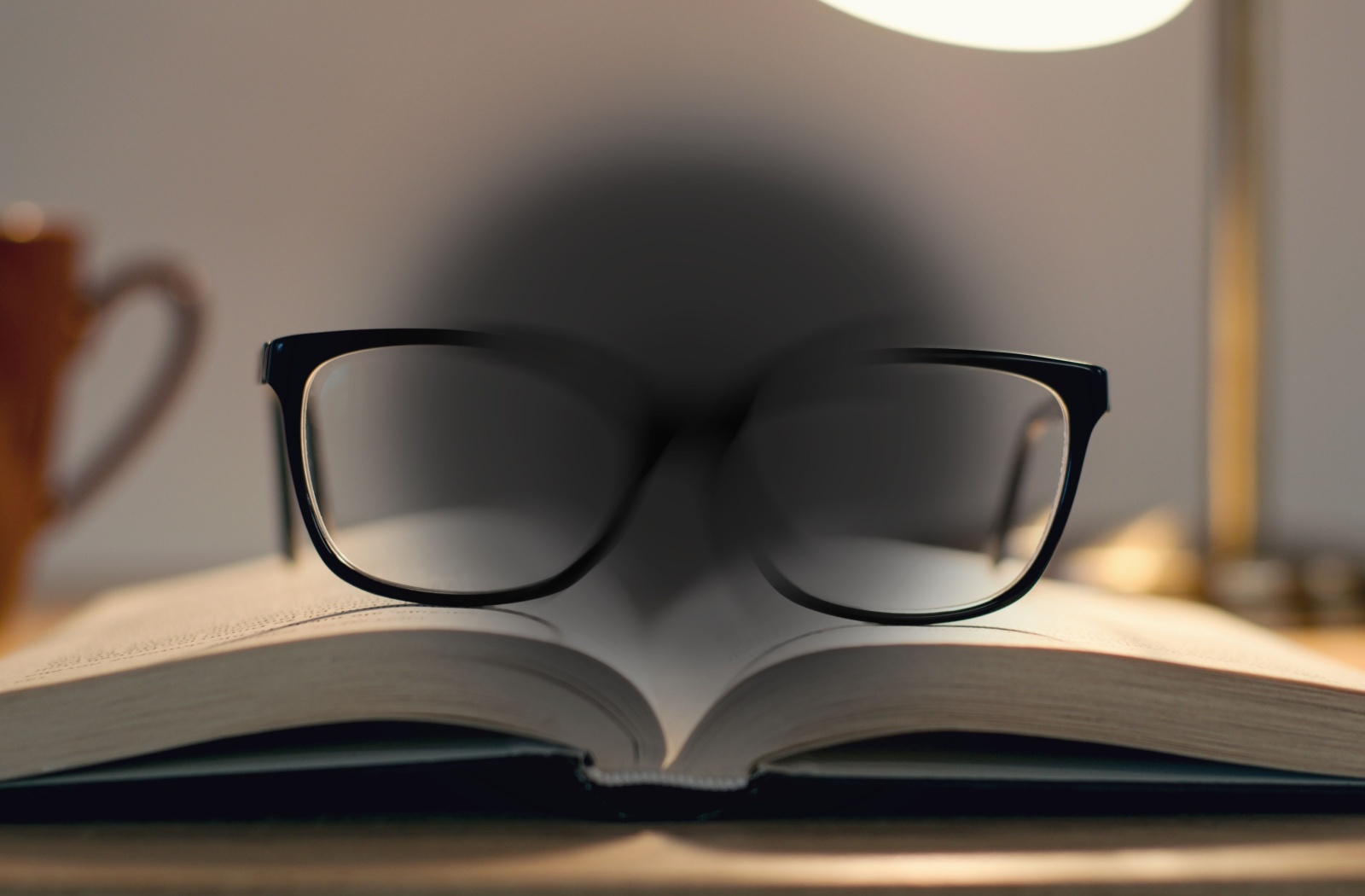 A first-person image of a pair of glasses on a book with a blank spot showing what vision is like with macular degeneration.
