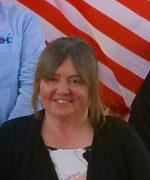A person smiling in front of a flag

AI-generated content may be incorrect.