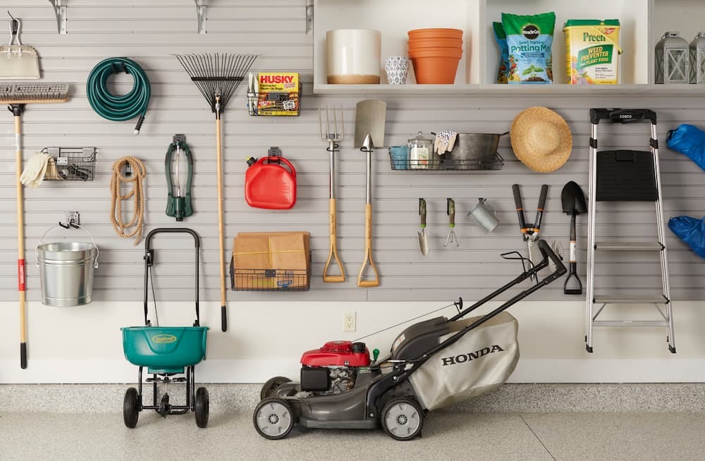 A clean and dry station with garden tools like mower, ladder, shovel, garden fork and the others.  It is one of the 7 garden storage hacks every gardener should know.