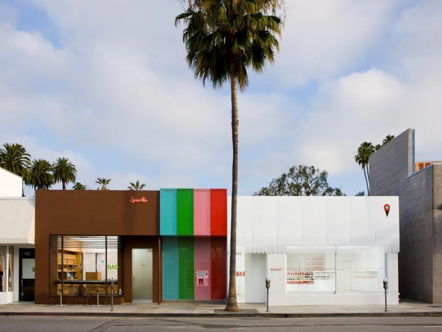 A building with colorful stripes and a palm tree Description automatically generated