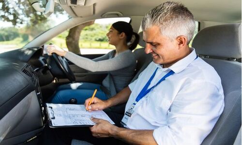 a woman practising their driving skills with an instructor
