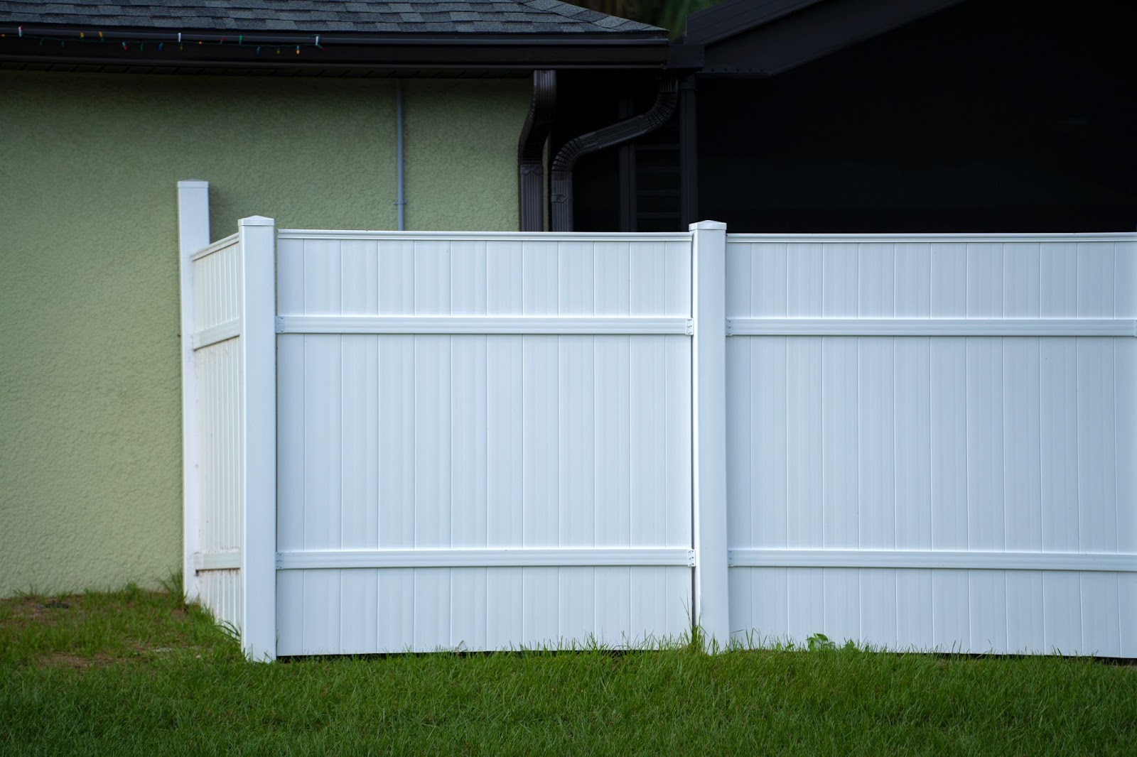 White vinyl fences on the green lawn surrounded the property.